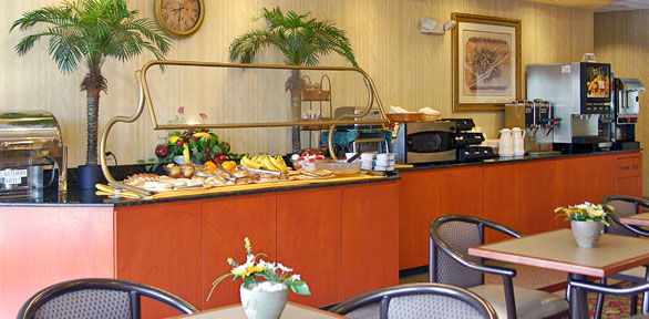 food buffet with fruits, cereal, hot drinks, cold drinks and sitting area